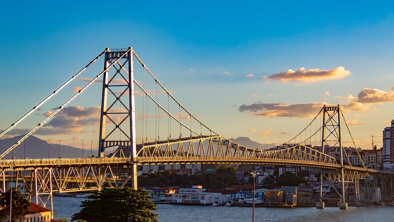 Ponte turistica com iluminação refletida pelo sol e céu com poucas nuvens