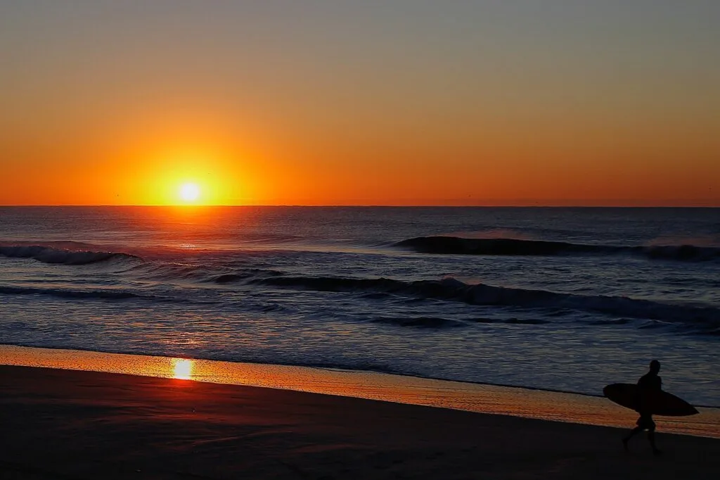 Praia do campeche com ondas e por do sol em laranja escuro